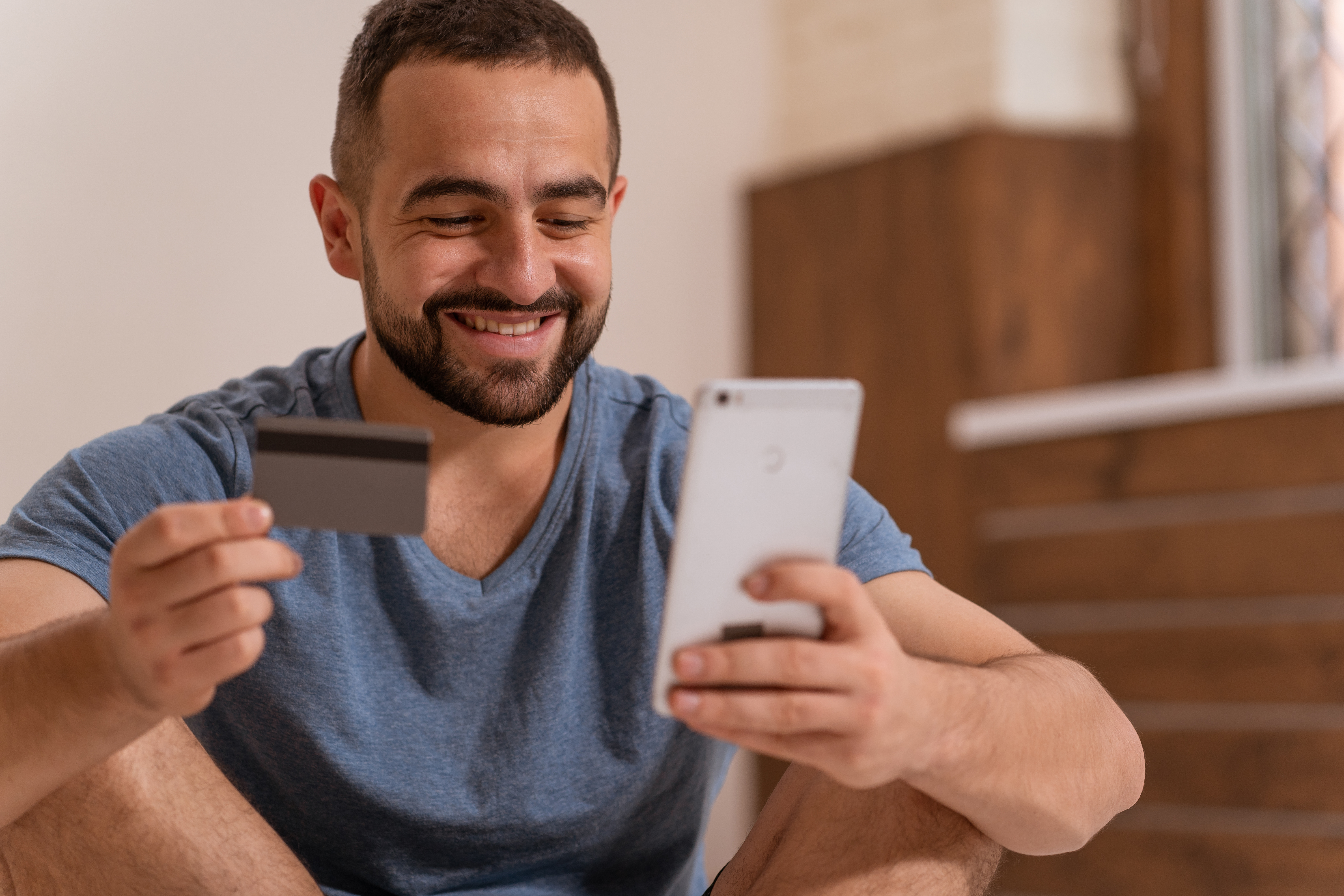 Man looking to his phone and card